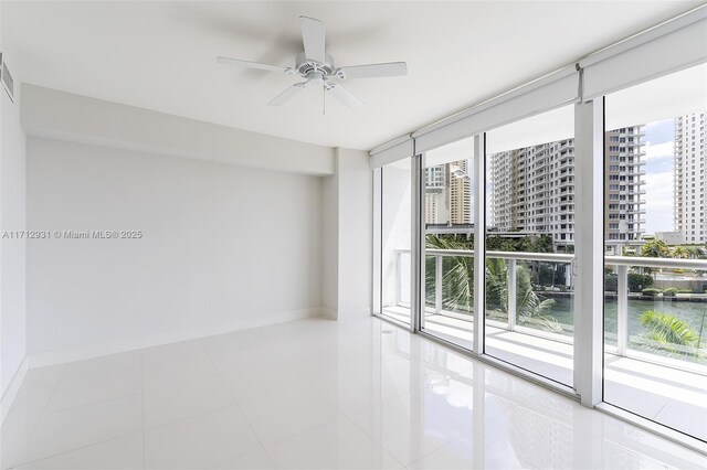 495 Brickell Ave Unit Bay407, Miami, FL 33131 - spare room featuring ceiling fan, baseboards, a water view, a city view, and tile patterned floors