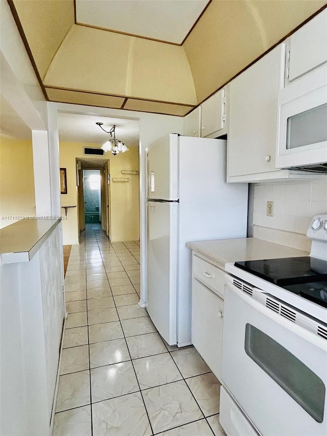 kitchen with white cabinets, decorative backsplash, white appliances, and an inviting chandelier