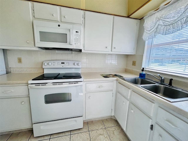 kitchen with white appliances, tasteful backsplash, white cabinetry, and sink