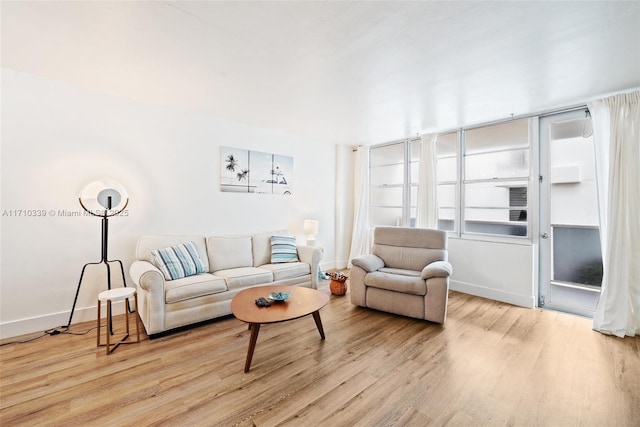 living area featuring baseboards and wood finished floors