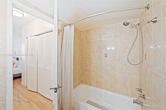 full bath featuring wood finished floors and shower / bath combo with shower curtain