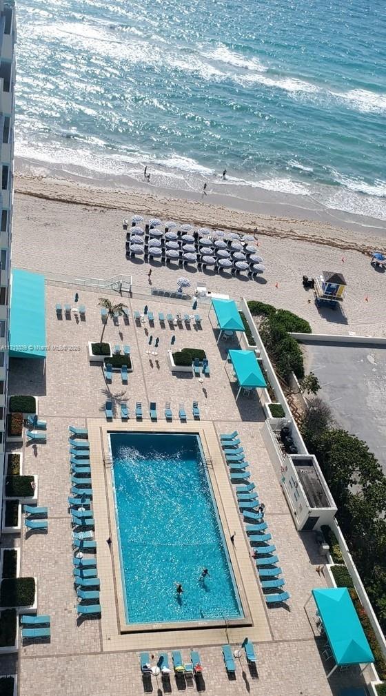 drone / aerial view featuring a beach view and a water view