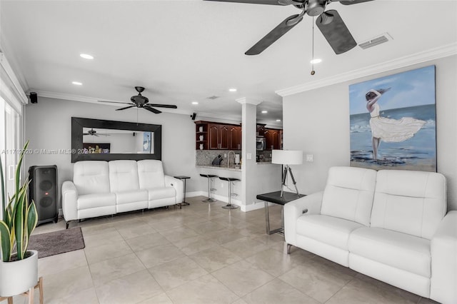 tiled living room with crown molding and sink