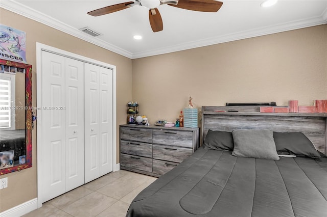 bedroom featuring ceiling fan, ornamental molding, light tile patterned floors, and a closet