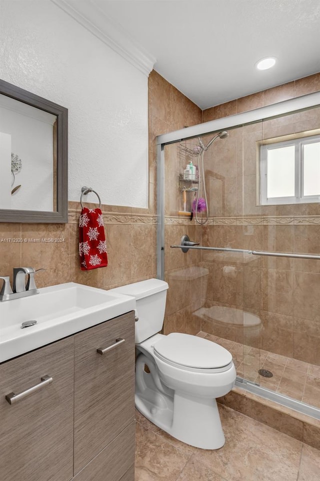 bathroom featuring vanity, tile walls, tile patterned flooring, toilet, and a shower with shower door