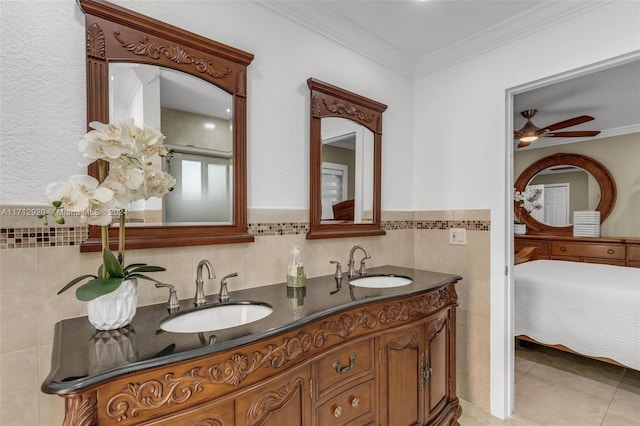 bathroom with tile patterned flooring, vanity, ornamental molding, and tile walls