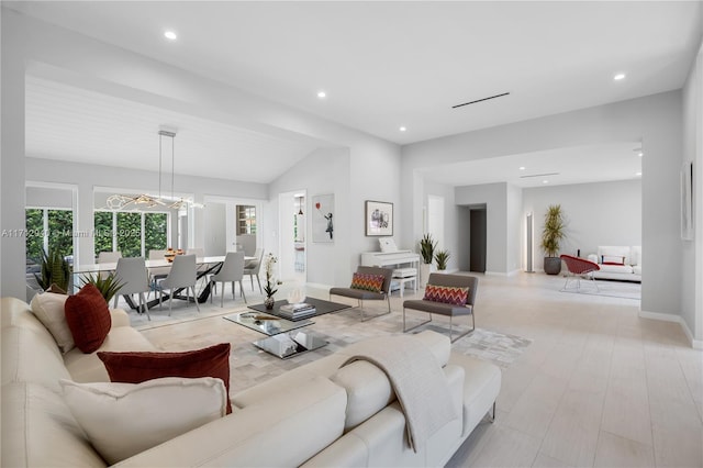 living room with an inviting chandelier and vaulted ceiling