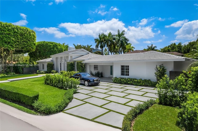view of front facade with concrete driveway, stucco siding, and a front yard