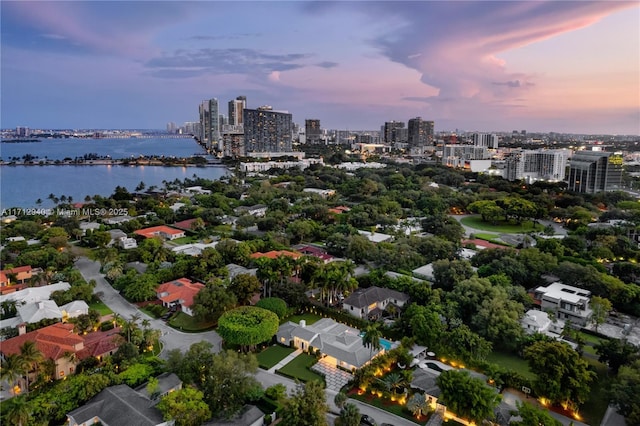 aerial view at dusk featuring a water view