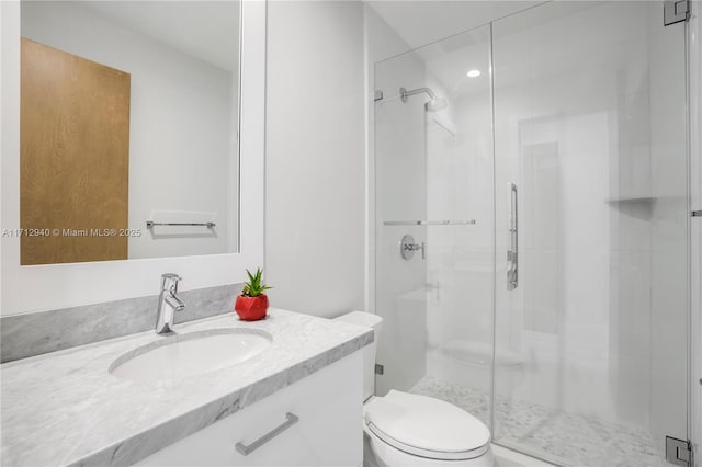 bathroom with toilet, a stall shower, and vanity