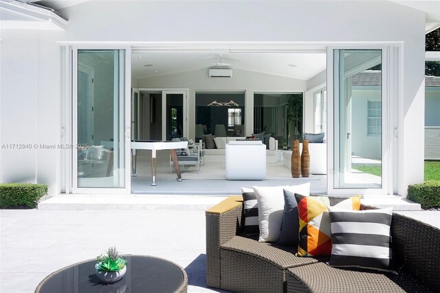 view of patio / terrace featuring an AC wall unit and outdoor lounge area