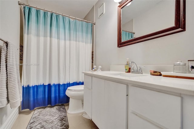 bathroom with tile patterned flooring, vanity, and toilet