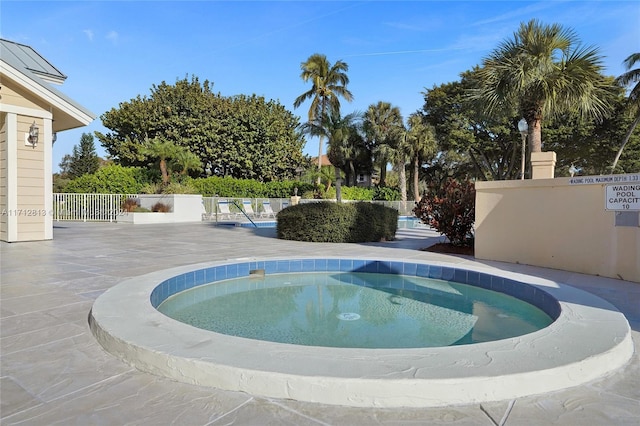 view of swimming pool with a hot tub