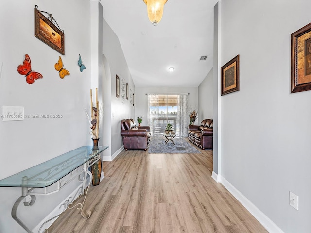 corridor with visible vents, baseboards, and wood finished floors