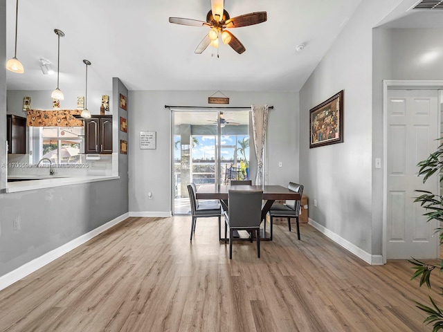 dining area featuring light wood-type flooring, a ceiling fan, and a wealth of natural light