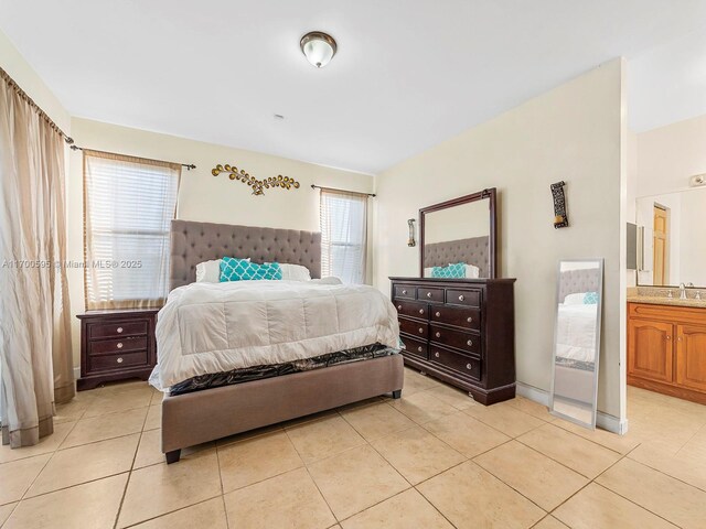 tiled bedroom with ensuite bathroom and sink