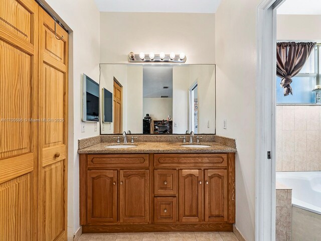 bathroom featuring tiled bath, tile patterned floors, and vanity