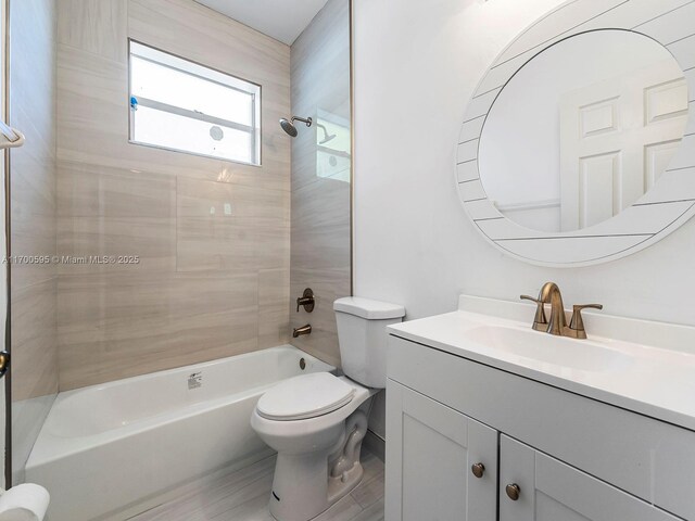 full bathroom featuring toilet, tiled shower / bath combo, and vanity