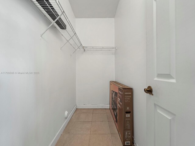 walk in closet with light tile patterned floors