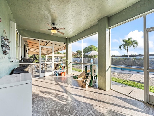 sunroom / solarium with a ceiling fan