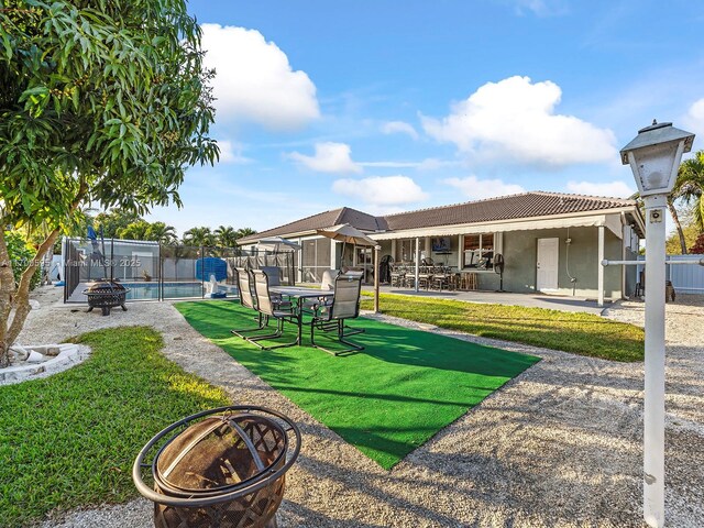 view of yard with an outdoor fire pit, a fenced in pool, and a patio