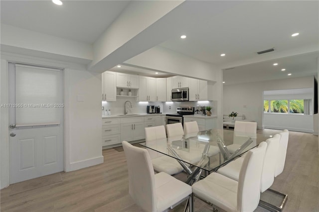 dining area featuring light wood-type flooring and sink