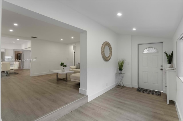 foyer entrance featuring light hardwood / wood-style floors and lofted ceiling