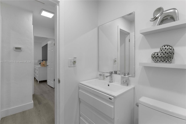 bathroom with vanity, hardwood / wood-style flooring, and toilet