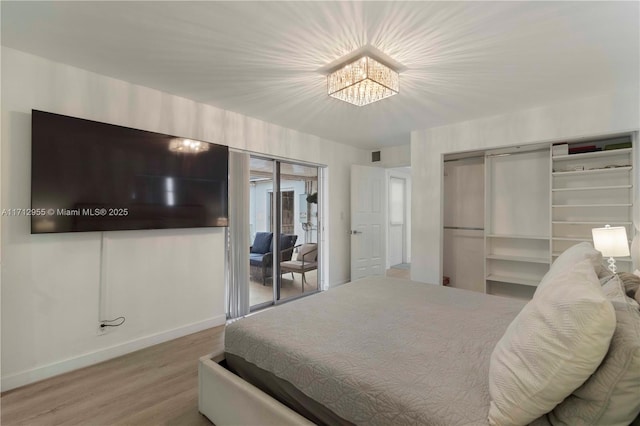 bedroom with hardwood / wood-style floors and a notable chandelier