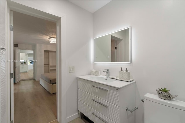 bathroom featuring hardwood / wood-style flooring, vanity, and toilet