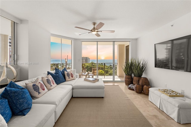 tiled living room with expansive windows and ceiling fan