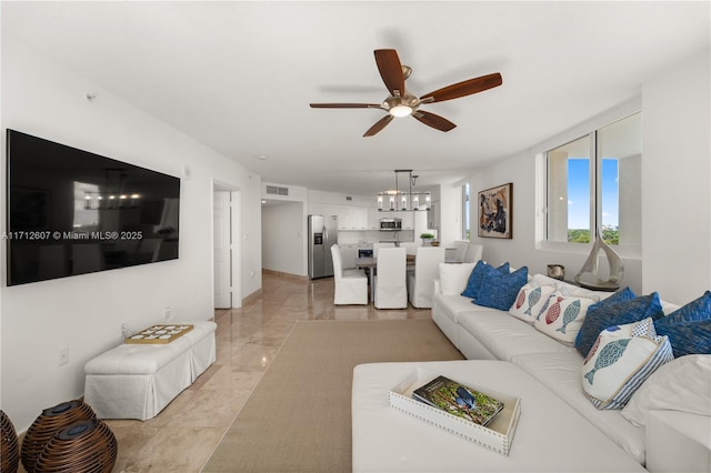 living room featuring ceiling fan with notable chandelier