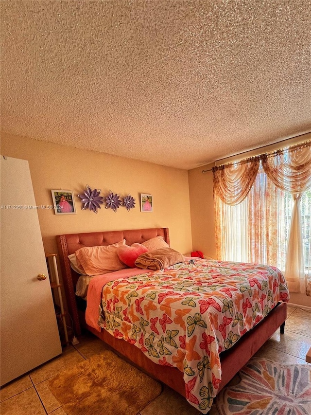 tiled bedroom featuring a textured ceiling