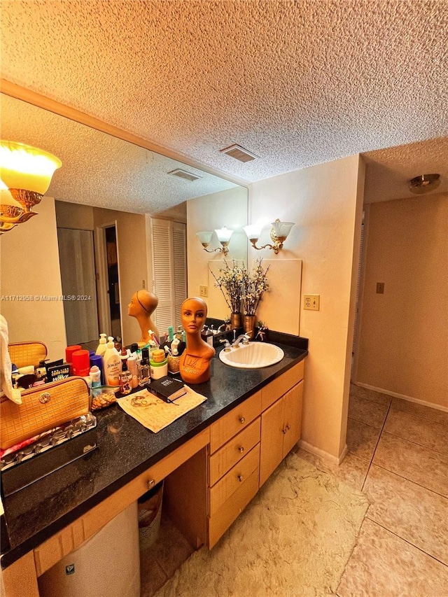 bathroom with tile patterned floors, vanity, and a textured ceiling