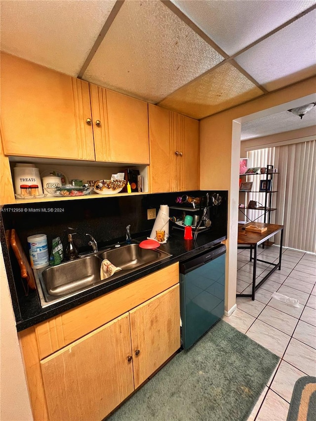 kitchen with light tile patterned floors, black dishwasher, and sink