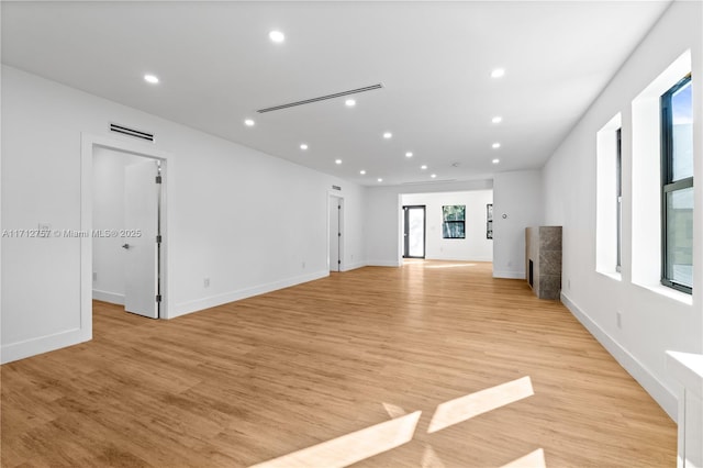 unfurnished living room with recessed lighting, visible vents, baseboards, and light wood finished floors