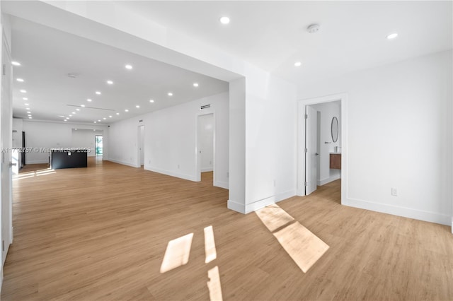 unfurnished living room featuring recessed lighting, baseboards, and light wood-style floors