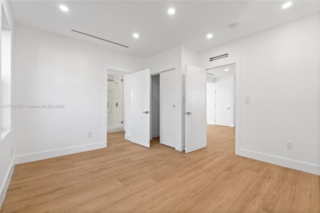 unfurnished bedroom featuring recessed lighting, baseboards, light wood finished floors, and connected bathroom