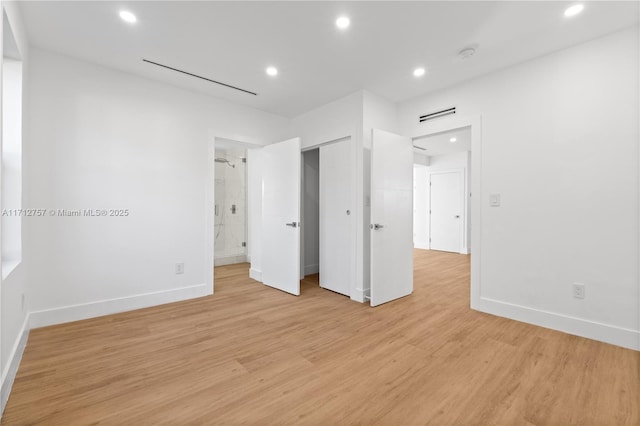 unfurnished bedroom featuring recessed lighting, baseboards, ensuite bath, and light wood finished floors
