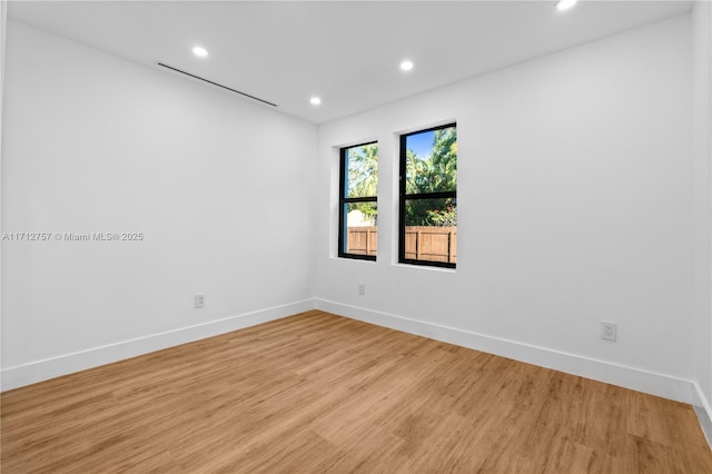 empty room featuring recessed lighting, light wood-type flooring, and baseboards
