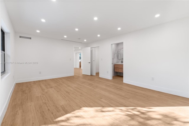 spare room featuring light wood finished floors, visible vents, recessed lighting, and baseboards