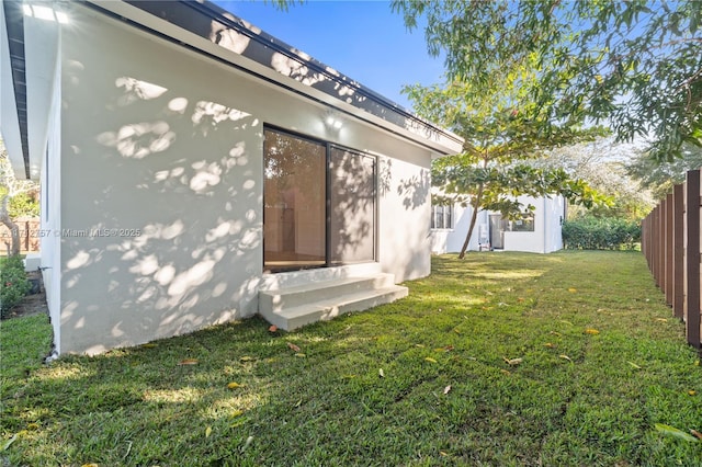 view of yard featuring entry steps and fence