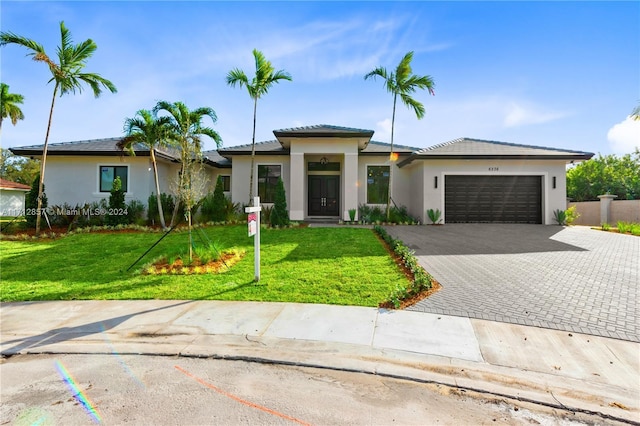 view of front of house featuring a front lawn and a garage