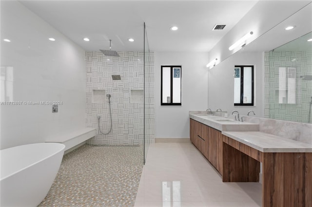 bathroom featuring separate shower and tub, vanity, and tile walls