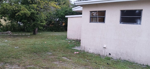 view of side of home with a lawn