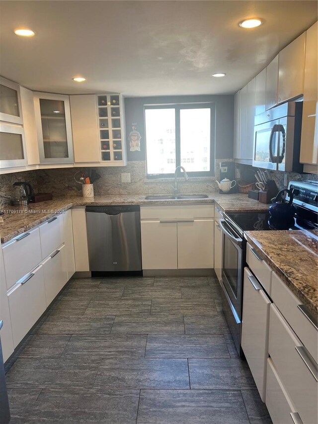 kitchen featuring white cabinets, stone countertops, sink, and appliances with stainless steel finishes