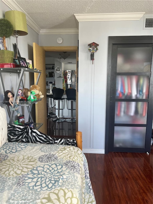 bedroom featuring crown molding, dark hardwood / wood-style floors, a textured ceiling, and stainless steel refrigerator with ice dispenser