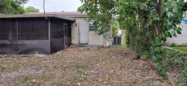 rear view of property with a sunroom and central AC