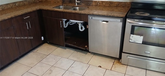 kitchen with appliances with stainless steel finishes, light tile patterned floors, dark brown cabinets, and sink