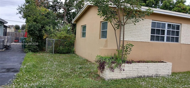 view of side of property featuring central air condition unit and a yard